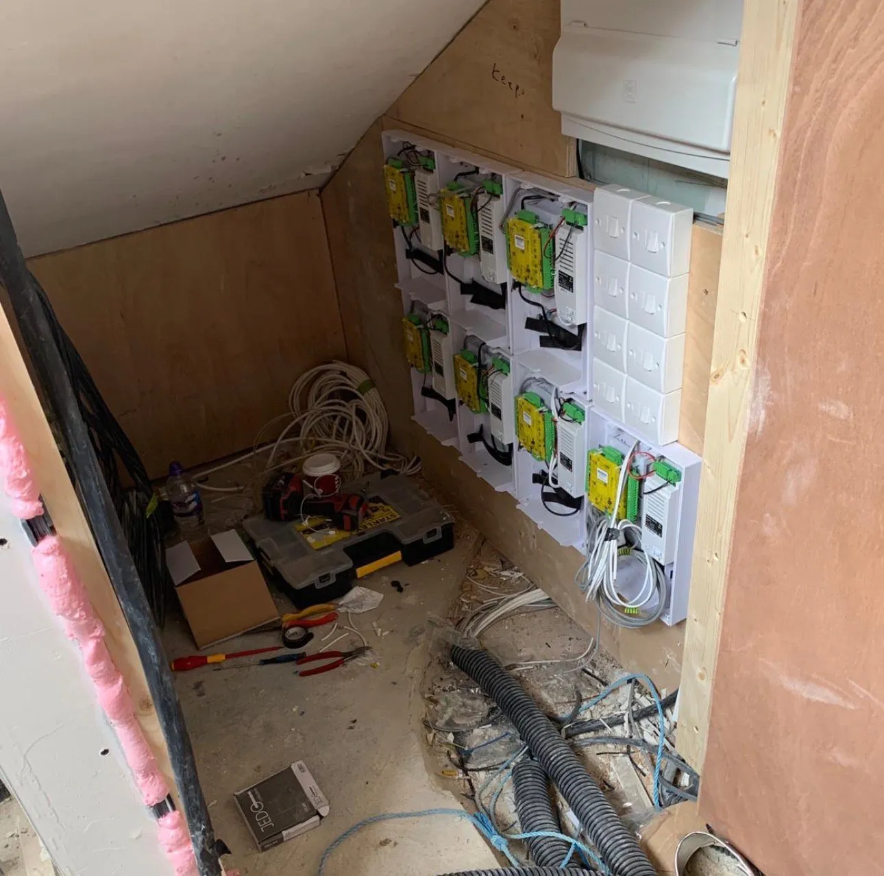 Multiple access control units and network sockets neatly installed within a loft cupboard.