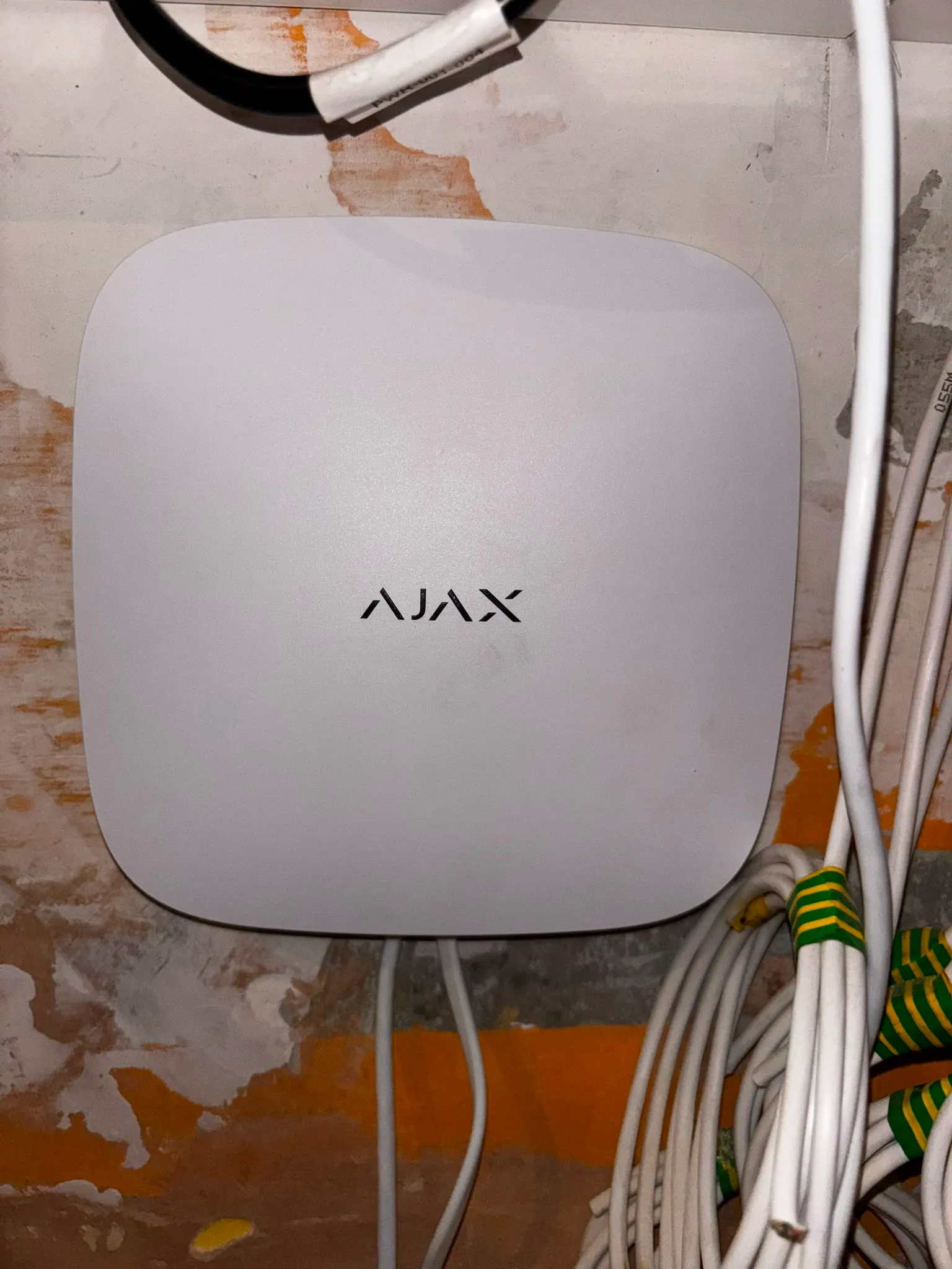Ajax control hub wall-mounted with power and network cabling run in and labelled.