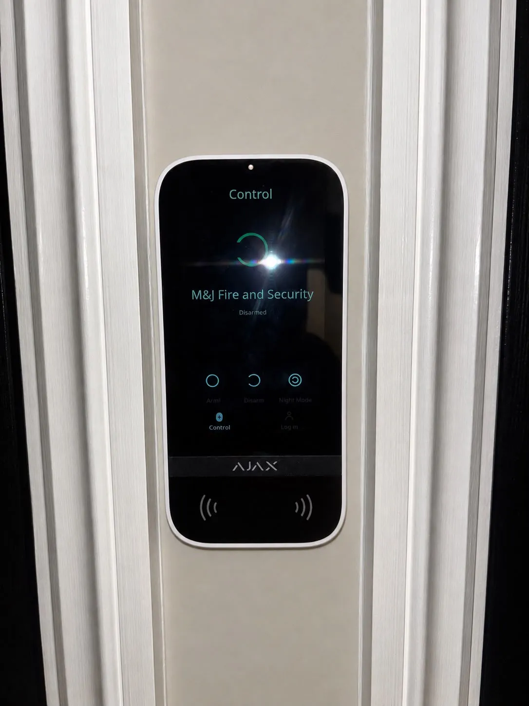 Ajax touchscreen keypad beside the front door, showing the system named and disarmed after handover.