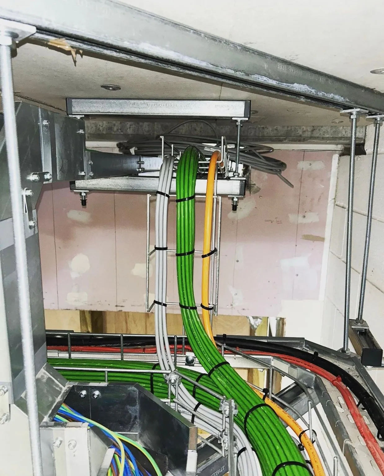 Structured cabling routed through ceiling voids on cable basket, cleanly organised and clipped.