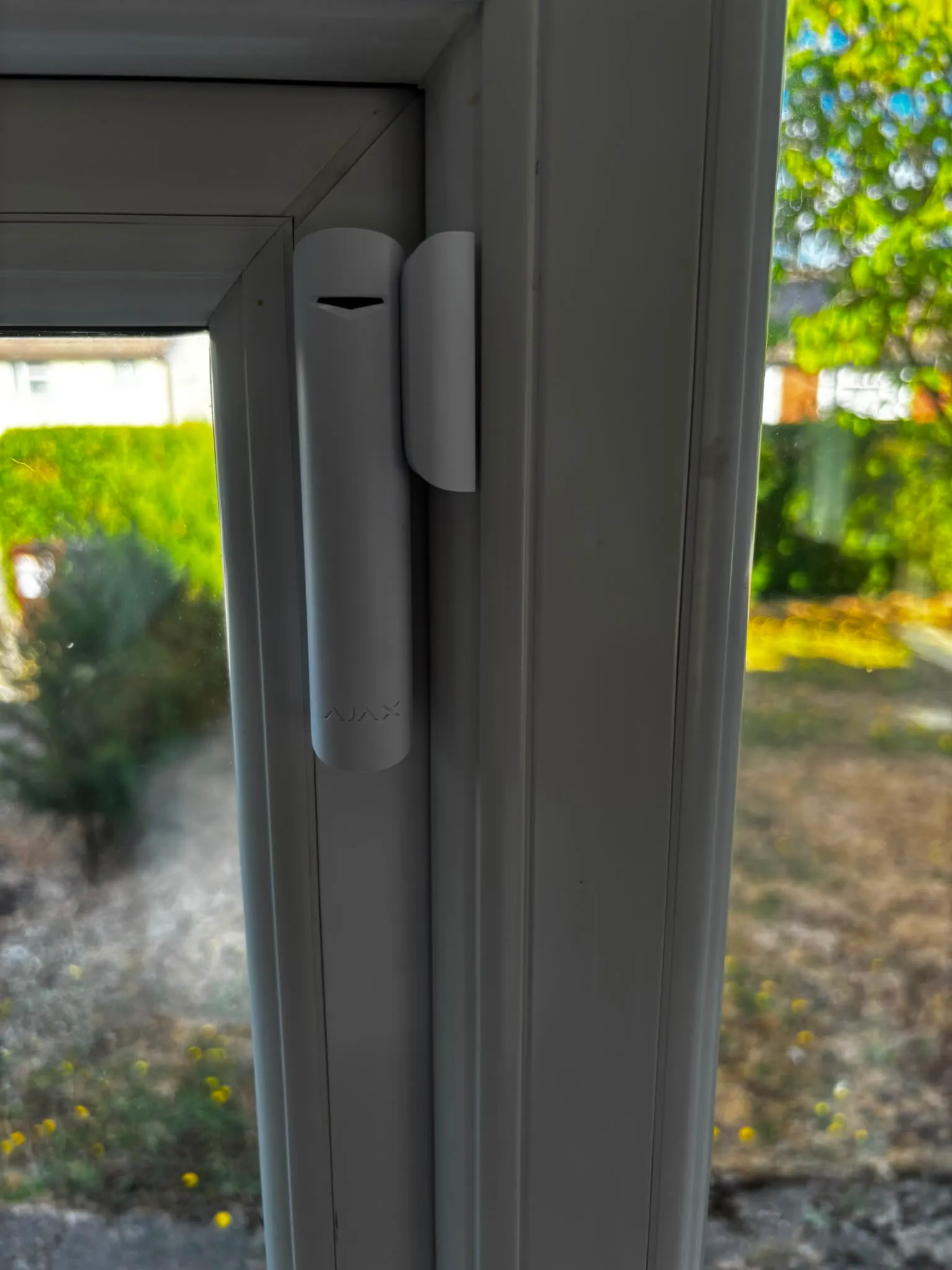 Ajax door contact on a garden door, sitting flush against the frame.