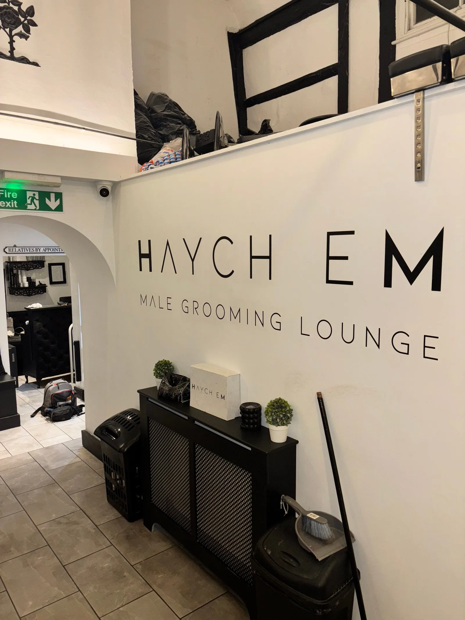 Discreet ceiling camera covering the salon interior and fire exit route.