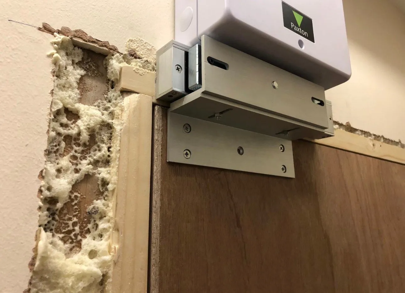 Paxton access control unit and magnetic door lock fitted above a fire-rated door frame.