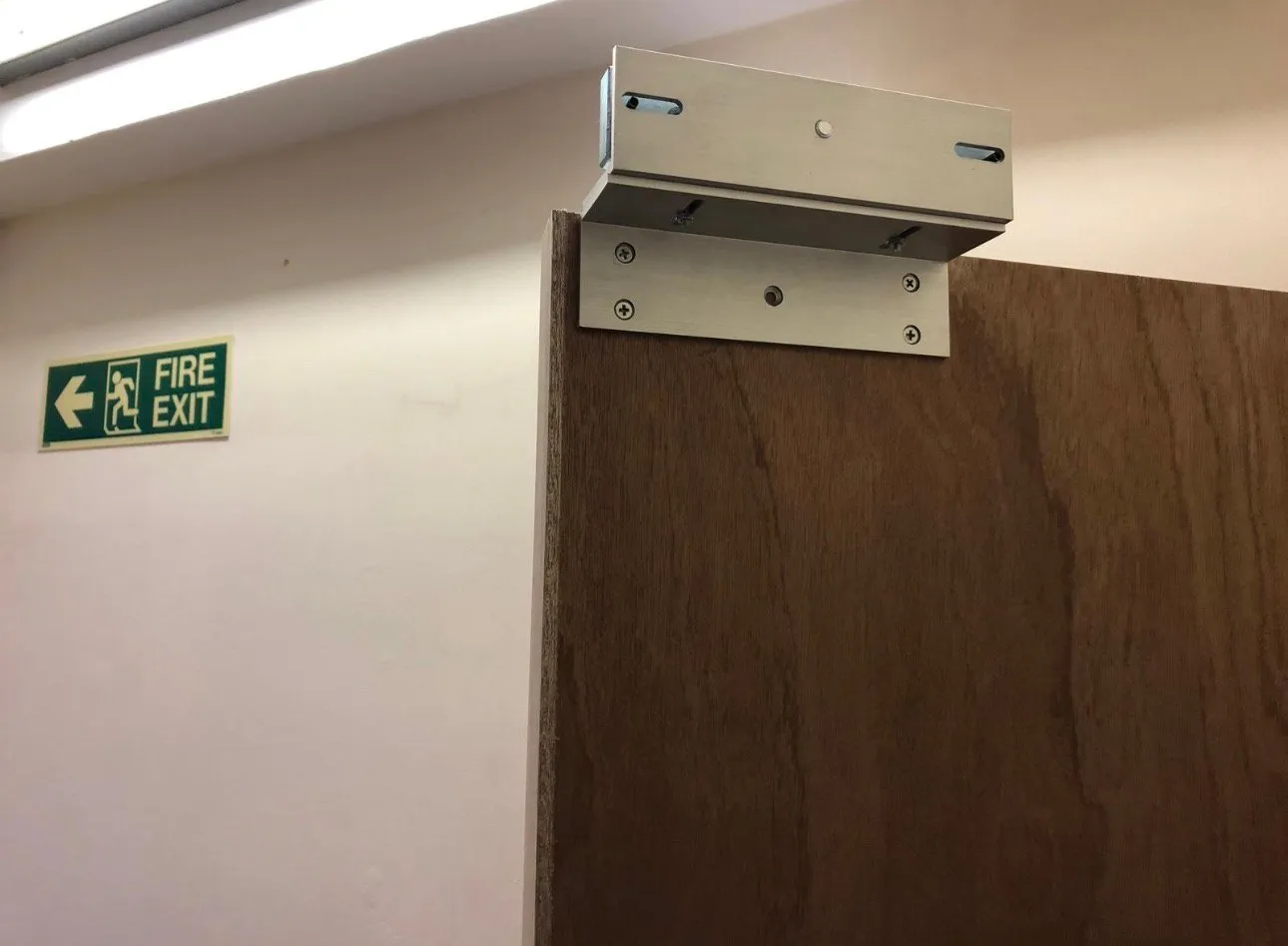 Magnetic door lock installed on a fire exit door, fully wired and ready for use.