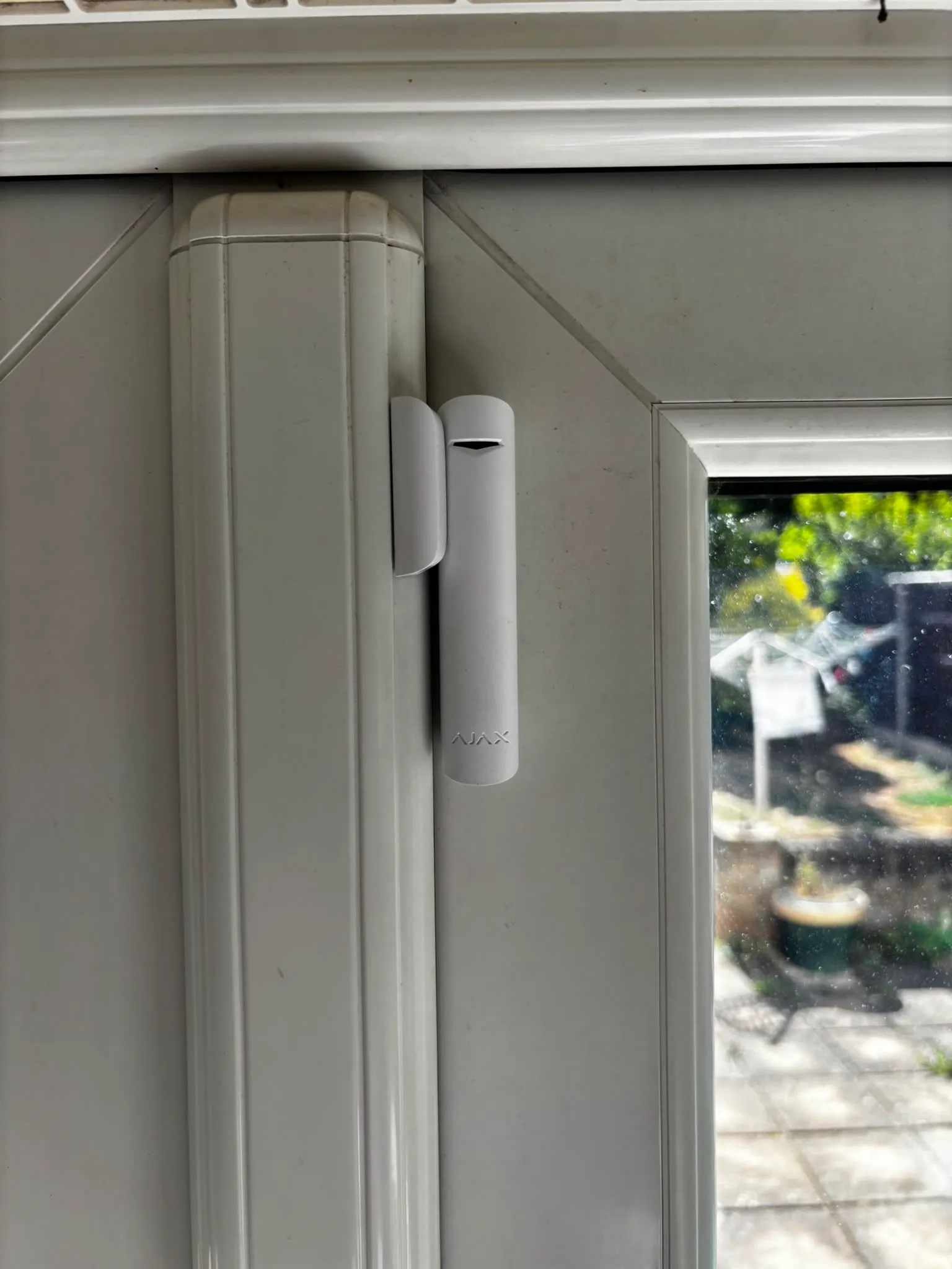 Ajax door contact on a patio door, mounted clear of the handle and locking points.