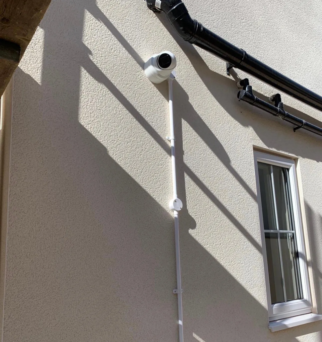 White dome camera on vertical pole mount with clean cable routing.