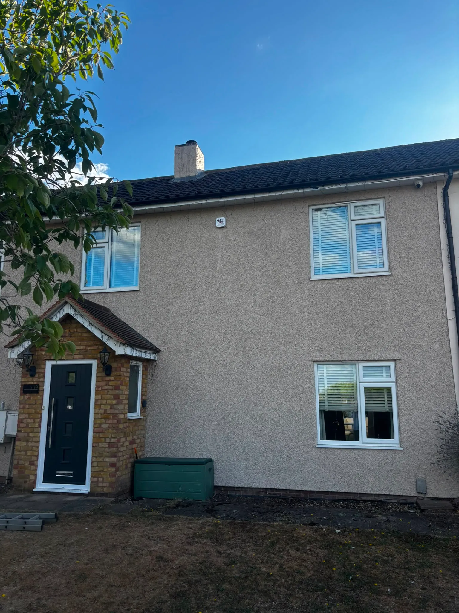 House frontage with the alarm sounder mounted high on the render and a CCTV camera under the eaves.