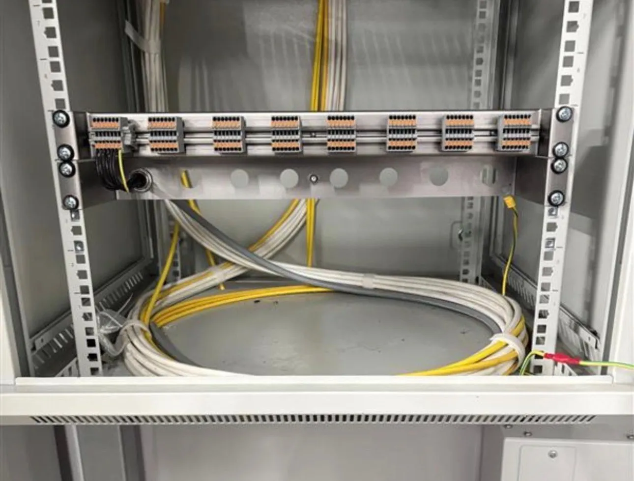 Data cabling terminated onto a connector block with cabling stored neatly below.